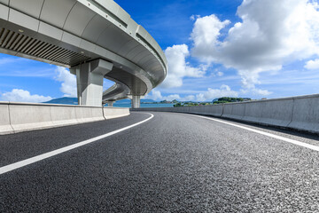 Asphalt road and bridge with sea scenery on a sunny day