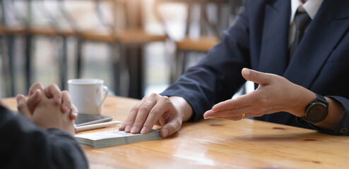 Two businesspeople having a business negotiation meeting in the office, A businessman giving a bribe to his business partner. Cropped and close-up image