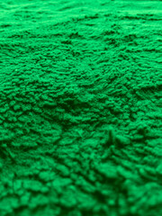 Green furry carpet close up, selective focus.