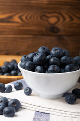 Blueberries in a bowl on a brown textured background. Ripe and fresh blueberries. Vitamins. Healthy food. Juicy berry. Copy space. Place for text