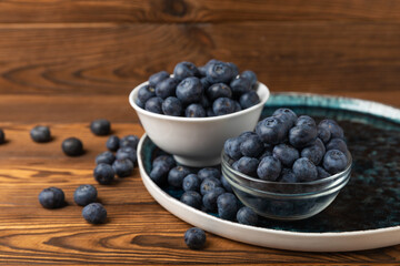 Blueberries in a bowl on a brown textured background. Ripe and fresh blueberries. Vitamins. Healthy food. Juicy berry. Copy space. Place for text