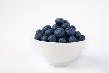 Blueberries in a bowl isolated on a white background. Ripe and fresh blueberries. Vitamins. Healthy food. Juicy berry. Copy space. Place for text