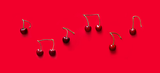 on red background notes from berries sweet cherry red color place inscription music notation camp copy space banner