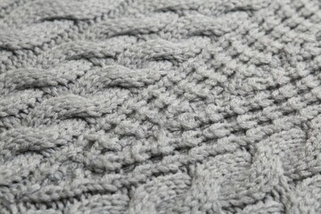 Grey knitted fabric with beautiful pattern as background, closeup