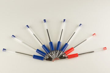 set of blue ballpoint pens lined up by an arc