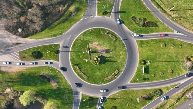 Aerial view of road roundabout intersection with fast moving heavy traffic. Urban circular transportation crossroads