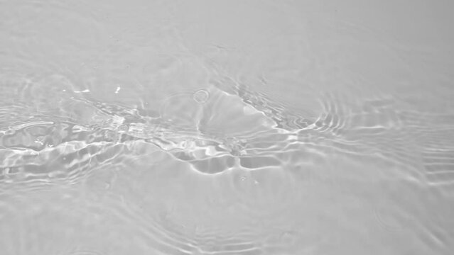 Transparent clear calm water surface texture with waves, splashes and bubbles. Trendy abstract nature background. White grey water waves in sunlight. Slow motion Full HD video banner.