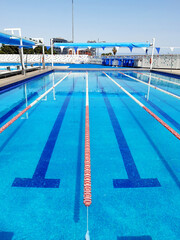 Swimming lane detail background in competition pool with floating lane lines. Water sport, swimming and competition concept.