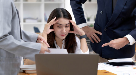 Frustrated and busy young Asian businesswoman or female worker working with her colleagues.
