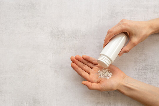Applying white talcum powder on hand. Skin care cosmetic