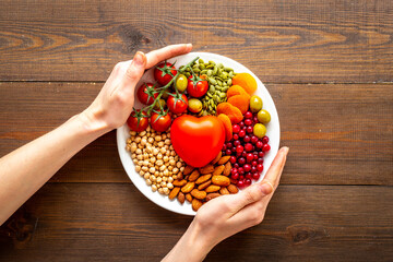 Hands holding dish with food for heart health. Cholesterol diet concept