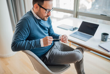 Thoughtful professional with a pen working at desk while sitting in office.