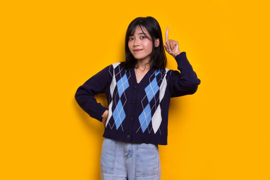 young beautiful asian woman thinking idea isolated on yellow background
