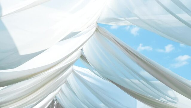 Close up footage of with white cloth in windy day above sun beds.