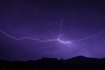 Fototapeta na wymiar Gewitter mit Blitz über dem Bergland