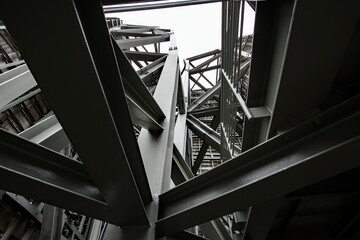 Contrasting shot of a metal structure showing strong angles of the beams and rivets. light beams shining through adding to the dramatic effect.
