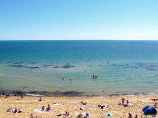 Fototapeta na wymiar View of Sandringham beach at Melbourne, Australia. Have people walking, swimming and sunbathing round of coast.