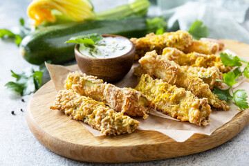 Healthy tasty snack, summer food. Zucchini fries. Crispy Zucchini sticks in breadcrumbs, with cheese with garlic yogurt sause.