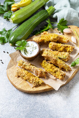 Healthy tasty snack, summer food. Zucchini fries. Crispy Zucchini sticks in breadcrumbs, with cheese with garlic yogurt sause. Copy space.
