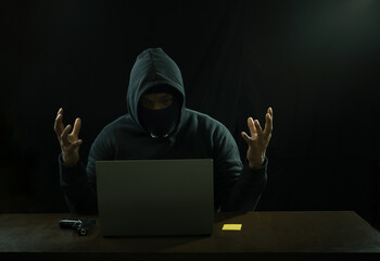 hacker hacking fail at night, stress man in black hoodie having a gun,credit card and...