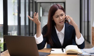 Stressed asian businesswoman or female marketing manager arguing on the phone with her colleague. Serious, Unhappy, Unsatisfied, Mad businesswoman.