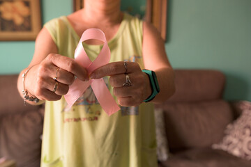 Unrecognizable woman holding pink breast cancer awareness ribbon