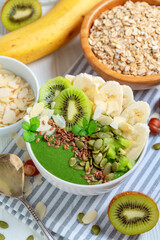 Breakfast smoothie bowl with spinach,banana and kiwi fruits.
