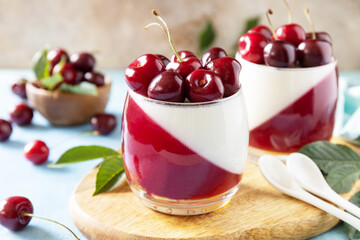Panna cotta with sweet cherry jelly on a stone tabletop, italian dessert, homemade cuisine.