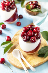 Panna cotta with sweet cherry jelly on a stone tabletop, italian dessert, homemade cuisine.
