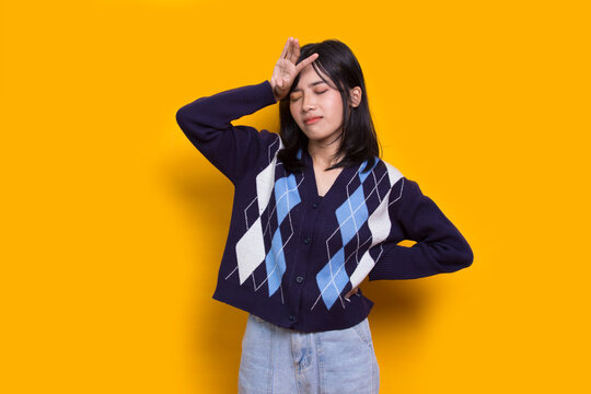 stressed sick asian woman tired with headache isolated on yellow background

