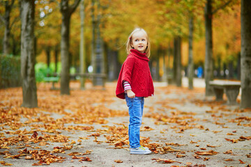 Adorable preschooler girl walking in Tuileries garden in Paris, on a fall day