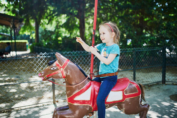 Adorable little girl on the playground. Preschooler girl having fun on vintage French...