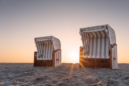 Zwei Strandkörbe am Meer im Sonnenuntergang