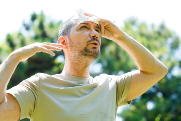 Young man having hot flash and sweating in a warm summer day.