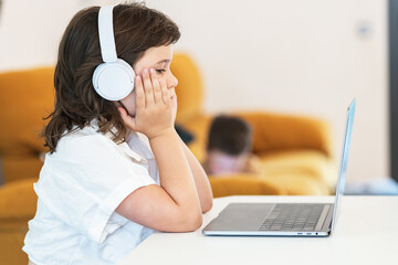 Girl with a bored face sitting in front of a laptop