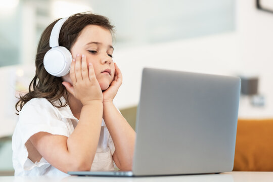 Girl with a bored face sitting in front of a laptop