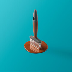 Paintbrush drowns in brown paint on a blue background. Creative concept of renovation.