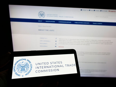 Stuttgart, Germany - 07-24-2022: Person Holding Smartphone With Logo Of US International Trade Commission (USITC) On Screen In Front Of Website. Focus On Phone Display.