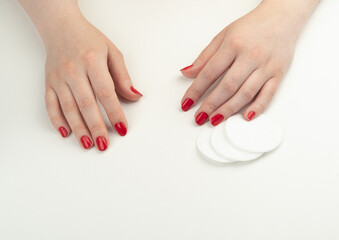 Young woman's nail polish and cotton pads.