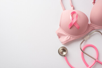 Breast cancer awareness concept. Top view photo of pink bra with pink ribbon and stethoscope on...