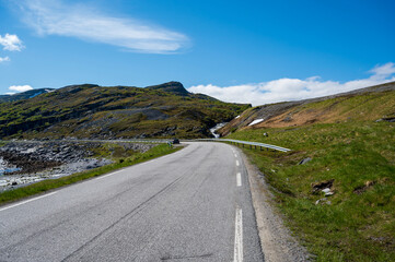 Narrow road in stone hills with stream
