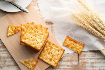 Heap of Dry thin crispy crackers on cutting board on wood table.Top view with copy space