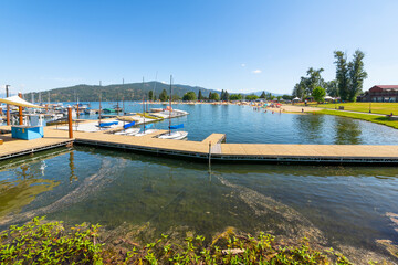 The marina and city beach area of downtown Sandpoint, Idaho, with boats filling the docks on Lake Pend Oreille on a summer day in the Idaho panhandle.