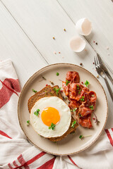 Breakfast, fried egg with bacon, micro-green, on a light background, no people, selective focus,