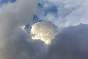Fototapeta na wymiar A big white cloud ball in sunlit like a cotton, on a dark sky background