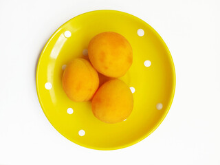 fresh apricots on a yellow plate