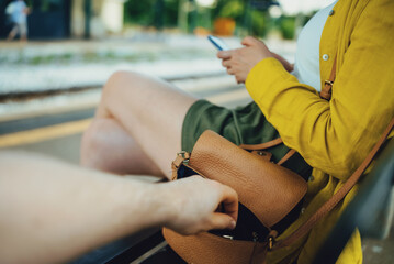 Thief robs a woman's handbag at the train station.
