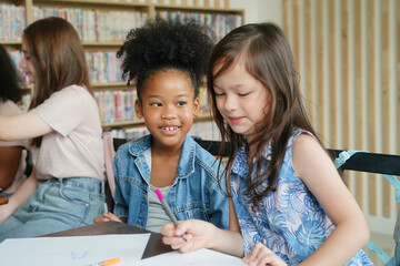 Fototapeta premium African kids drawing and do homework in classroom, young girl happy funny study and play painting on paper at elementary school. Kid drawing and painting at school