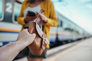 Thief robs a woman's handbag at the train station.