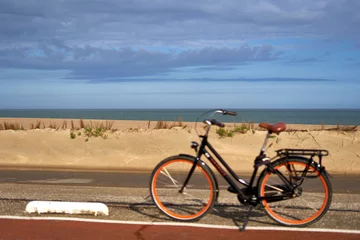 Papier Peint photo autocollant Mer du Nord, Pays-Bas Vélo flou devant la mer du Nord néerlandaise. Dune de sable devant un ciel bleu nuageux un jour d& 39 été. Faire du vélo aux Pays-Bas, en Zélande, à Brouwersdam.